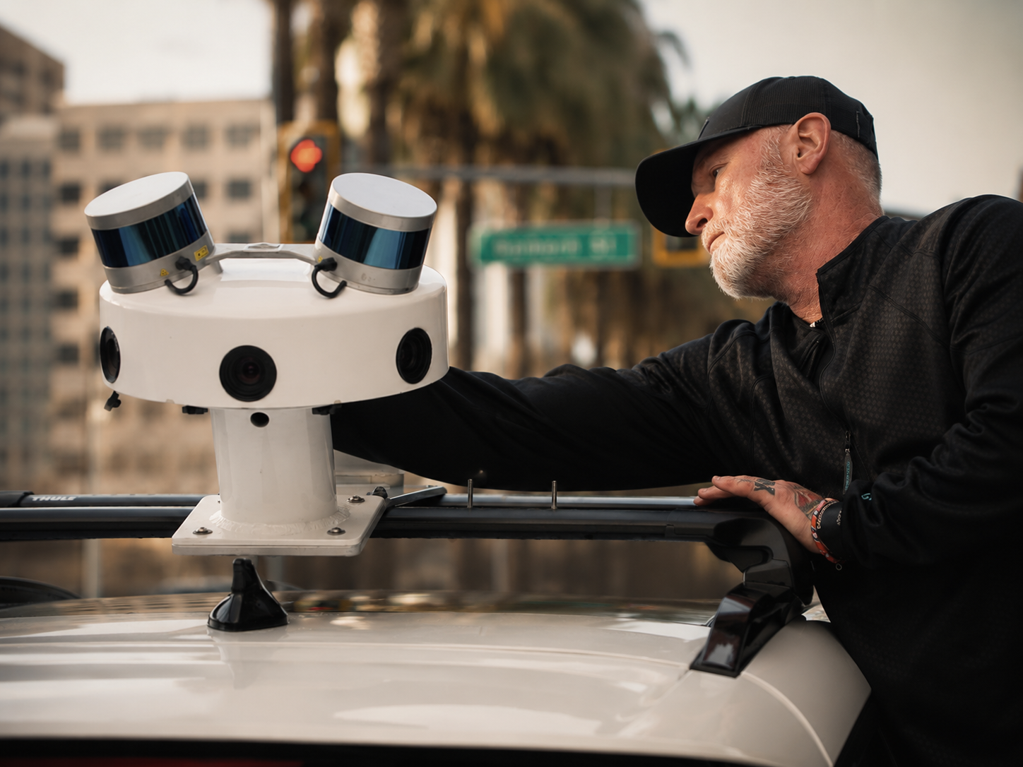 Robotic Data engineer adjusting a SYMBO multi-sensor unit mounted on a vehicle in San Jose